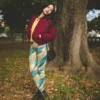 Woman wearing Ncharnt Ankle-length Teal and Yellow Leggings standing in forest Woman wearing Ncharnt Ankle-length Teal and Yellow Leggings standing in forest