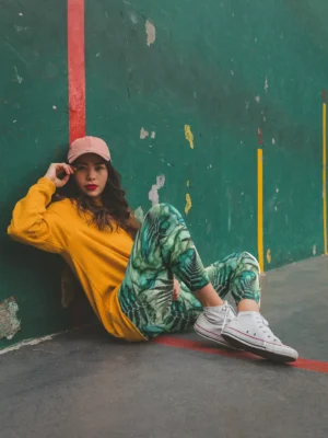 Stylish woman sitting on basketball court wearing NCharnt Green Ferns Leggings