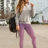 Woman casually standing in NCharnt versatile workout pants in purple and rose ombre Woman casually standing in NCharnt versatile workout pants in purple and rose ombre
