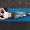 Woman in NCharnt sculpting athletic leggings in blue and brown gradient lying on a yoga mat Woman in NCharnt sculpting athletic leggings in blue and brown gradient lying on a yoga mat