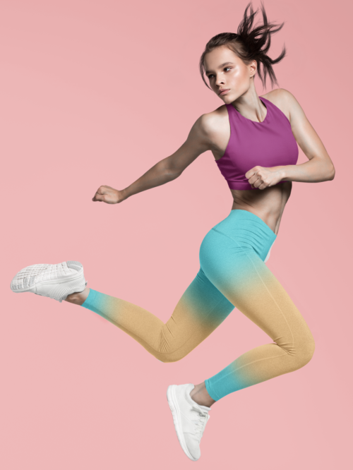 Woman jumping wearing NCharnt trendy sports leggings in blue and orange ombre Woman jumping wearing NCharnt trendy sports leggings in blue and orange ombre