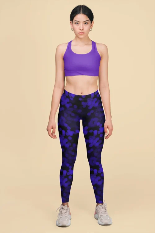 Woman standing wearing NCharnt stylish workout tights blue dots on black Woman standing wearing NCharnt stylish workout tights blue dots on black