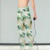 Woman wearing NCharnt Green and Beige Leaf Activewear for Women Leggings, holding a jump rope
