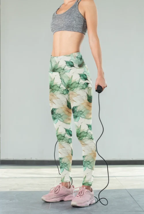 Woman wearing NCharnt Green and Beige Leaf Activewear for Women Leggings, holding a jump rope Woman wearing NCharnt Green and Beige Leaf Activewear for Women Leggings, holding a jump rope