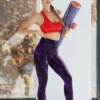 Woman with yoga mat wearing NCharnt texture print gym wear leggings in purple and black Woman with yoga mat wearing NCharnt texture print gym wear leggings in purple and black