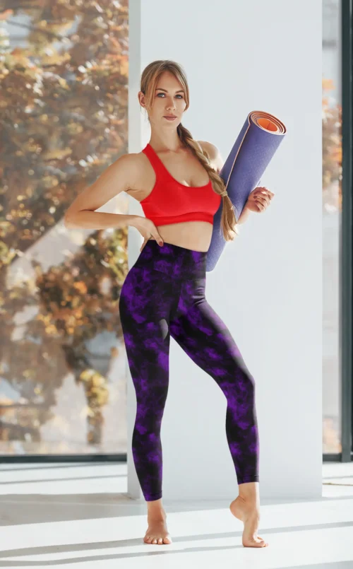 Woman with yoga mat wearing NCharnt texture print gym wear leggings in purple and black Woman with yoga mat wearing NCharnt texture print gym wear leggings in purple and black